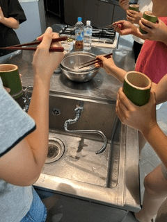手作りのお椀を持って食べている様子
